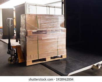 Heavy Shipment Box Loading Into Cargo Container. Truck Parked Loading At Dock Warehouse.