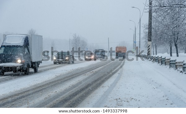 Heavy snow in the city, roadway with cars in the\
snow, ice.