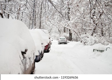 Heavy snowfall. On the road, snow-covered cars are parked. - Shutterstock ID 1193269636