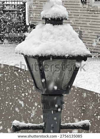 Heavy spring snowfall on lamppost