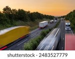 heavy traffic moving at speed on UK motorway in England at sunset