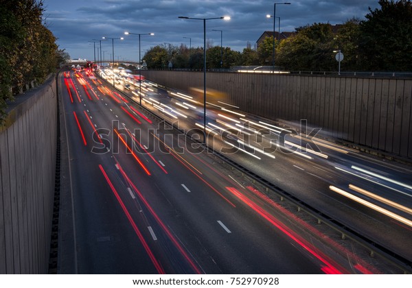 Heavy traffic at rush hour as drivers\
leave London on the A40 highway, leaving motion\
blur