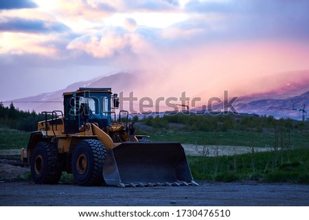 heavy wheel excavator machine at sunset
