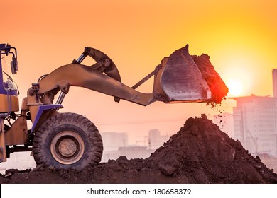 heavy wheel excavator machine working at sunset
