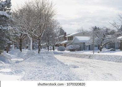 Heavy winter snow fall in a Canadian city street in residential area with roads cleared from snow - Powered by Shutterstock