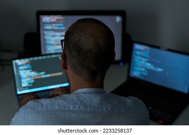 Heavy workload concept. Male coding with three screens at office - Shutterstock ID 2233258137