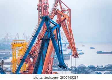 Heavy-duty harbor cranes loading and unloading cargo in maritime logistics hub near Shanghai.