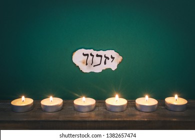 Hebrew inscription "remember" on a piece of paper and Six candles