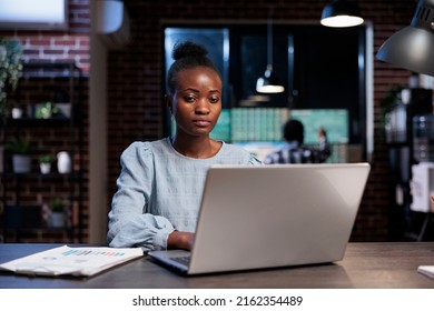 Hedge fund trading company professional employee sitting at desk while working on laptop to analyze financial data. Brokerage agent in office workspace, using computer to predict next market crash.