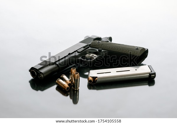 Hefty 1911 semi automatic handgun\
unloaded next to 8 round magazine and 4 loose hollow point bullets\
is a good choice for home protection from\
crimminals.