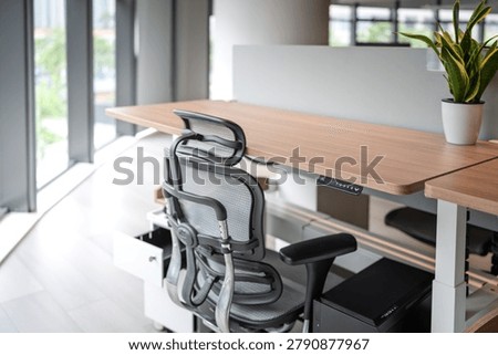 height adjustable standing desk and ergonomic chair in modern office space
