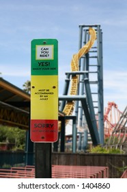 Height Check Sign With A Roller Coaster In The Background