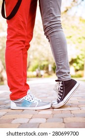 Height Difference. Portrait Of Legs Of Two Young People Standing In Park.