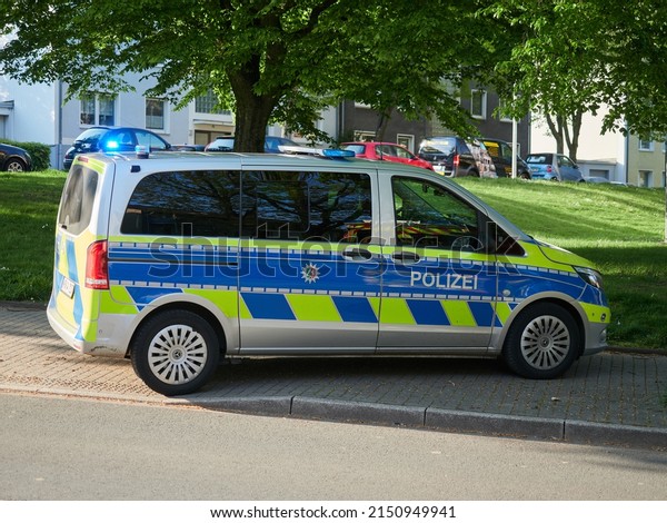 Heiligenhaus, Germany - April 27, 2022: A police\
patrol car parked on the sidewalk during a police intervention.\
Police bus.