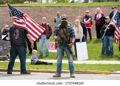 Helena, Montana - May 20, 2020: An armed man, militia member, protest at the Capitol building, holding a semi-automatic weapon in front of a group of protestors, member of The Continentals with a gun.