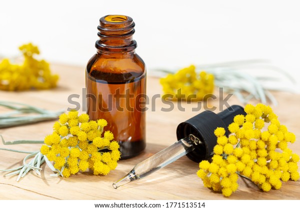 Helichrysum essential oil in amber bottle and
pipette. Herbal remedies
oil