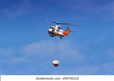 Helicopter Being Used To Collect Water From A Local Lake To Fight Wild Fire In The Mountains Behind The Glencairn Suburb