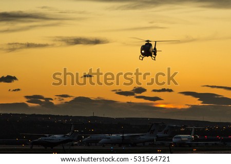 A helicopter coming in to land at sunset