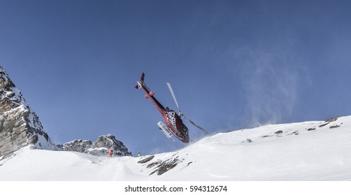 Helicopter Doing A Crazy Stunt At The Matterhorn In Switzerland, After Having Dropped Off Some Snowboarders And Skiers On The Mountains. Rescue Mission. 