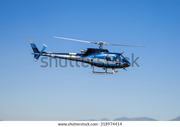Helicopter in flight. Fly over the mountain and blue\
sky. 