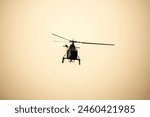 Helicopter flying away om isolated sky during dawn