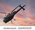 Helicopter flying over the heads into the sunset