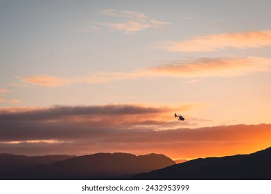 A helicopter on the way to the outer Hebrides flys off into the sunset.  - Powered by Shutterstock