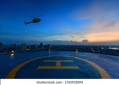 Helicopter parking landing on the roof of a skyscraper with cityscape view at sunset
