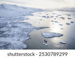 A helicopter view of the snowy mountains and fjords of Greenland in autumn. The west coast of Greenland between Ilulissat and Uummannaq. 