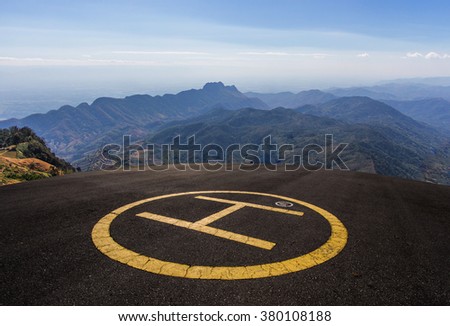Helipad on the roof of a skyscraper with mountain view