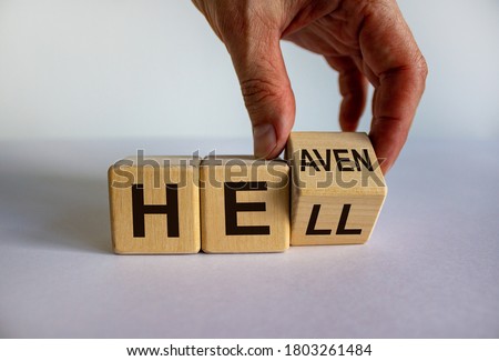 Hell or heaven. Hand turns a cube and changes the word 'hell' to 'heaven'. Concept. Beautiful white background, copy space.