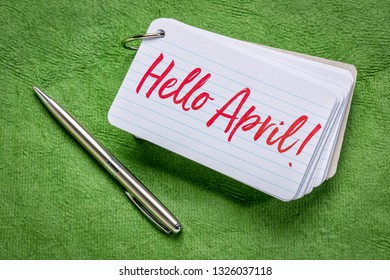 Hello April  - Handwriting On An Index Card With A Pen Against Green Textured Paper