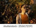 Hello autumn. tired trendy female in fitness clothes in the park relaxing after workout.