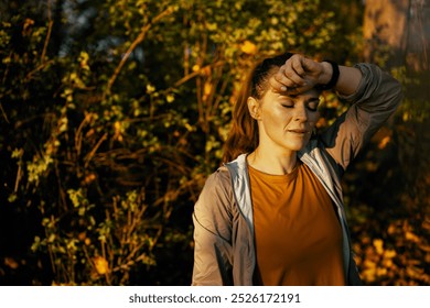 Hello autumn. tired trendy female in fitness clothes in the park relaxing after workout.