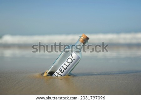Hello! Bottle on beach with greetings. Message in a bottle