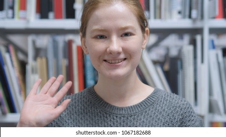 Hello by Young Female Sitting on Chair at Home, Waving Hand