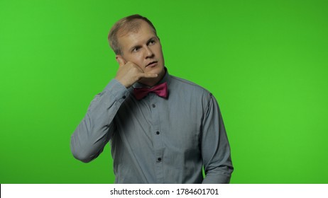 Hello, call me. Happy man standing with telephone hand gesture near head and pretending to communicate by phone, pointing finger to camera. Portrait of guy on chroma key background. People emotions - Powered by Shutterstock