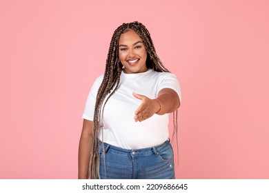 Hello. Cheerful African American Obese Lady Stretching Hand For Handshake Greeting Meeting You Smiling To Camera Posing On Pink Studio Background. Deal And Partnership Concept - Powered by Shutterstock