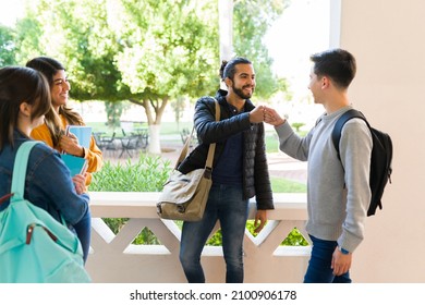 Hello! Cheerful College Students Giving A Fist Bump And Saying Hi After Arriving For Class In The Morning