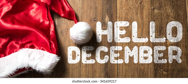 Hello December written on wooden background with Santa Hat - Powered by Shutterstock