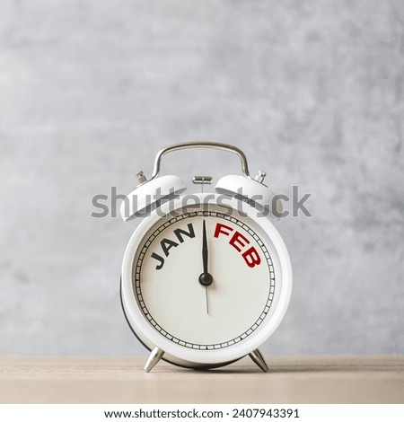 Hello February Changed from January  month with vintage alarm clock on table background. Calendar, Monthly, New Start, Resolution, Goals, Plan, Action and Mission Concept