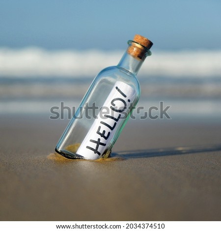 Hello! Greetings message in a bottle. Bottle found on beach with greeting.