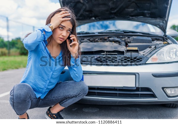 Hello, I have problems with my car! Calling\
Emergency Service. Young woman with a broken car. Sad girl with a\
broken car with open hood. Broken car, accident, feeling confusion\
and people concept