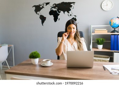 Hello, how can I help you? Hispanic young woman working at a travel agency and talking with a client about booking a flight for a business trip