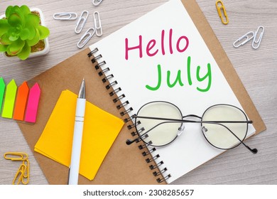 hello july on notepad on wooden background - Shutterstock ID 2308285657