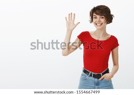 Hello nice to meet you. Cheerful outgoing good-looking girl approaching new member coworker raise hand up waving palm hi greeting gesture smiling friend wanna be friends stand white background