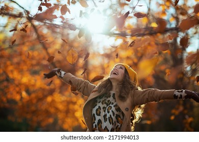 Hello November. Smiling Trendy 40 Years Old Woman In Beige Coat And Orange Hat Rejoicing Outside In The City Park In Autumn.