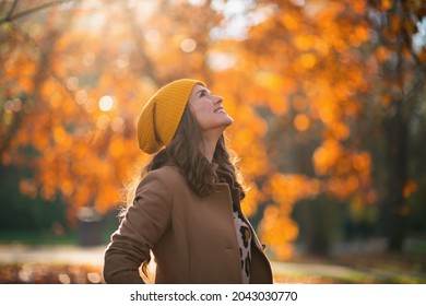 Hello October. Happy Trendy Woman In Brown Coat And Yellow Hat Outdoors In The City Park In Autumn.