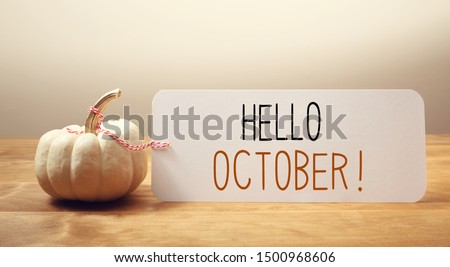 Hello October message with a white small pumpkin