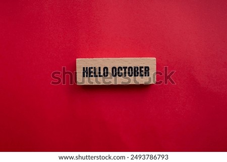 Hello october message written on wooden block with redbackground. Conceptual hello october symbol. Copy space.